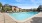 Large sparkling blue pool with a large pool deck and lounge chairs